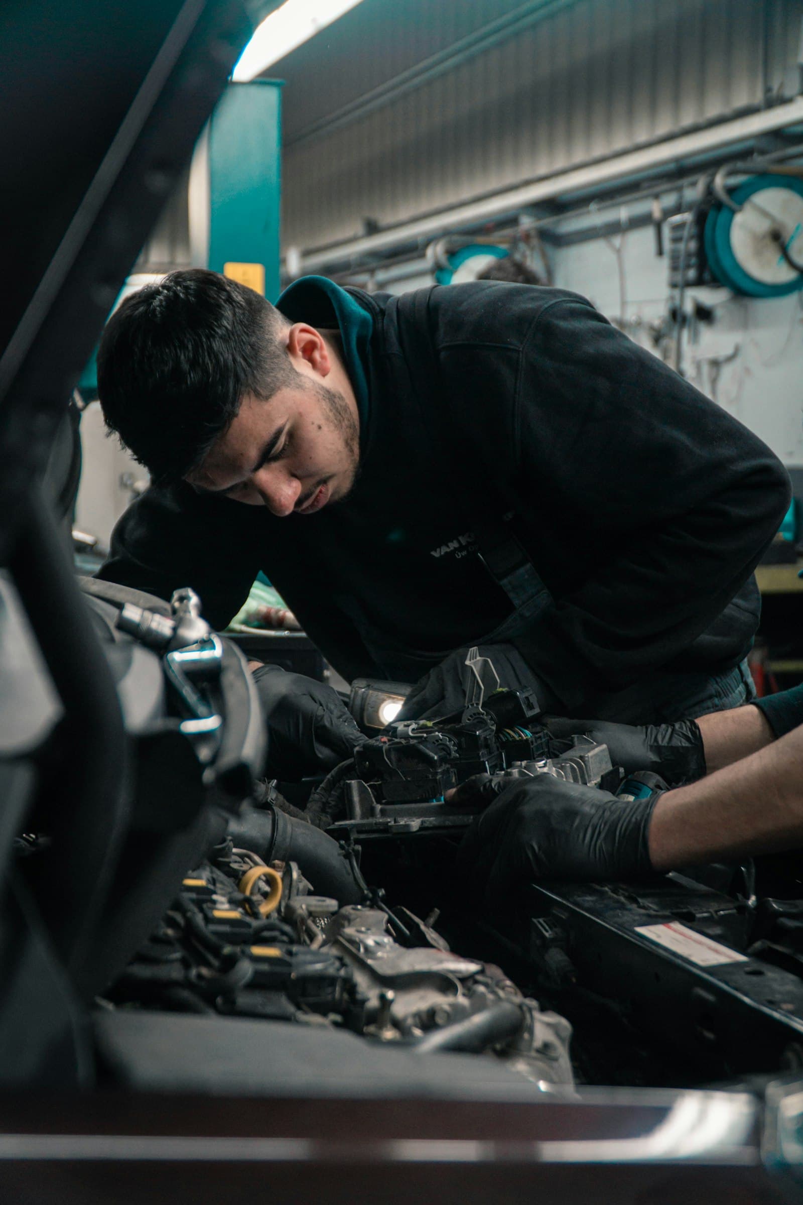 Mechanic connecting wiring in a vehicle engine bay